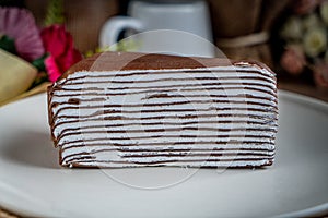Chocolate crepe cake on white plate