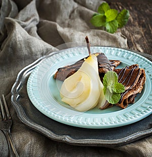 Chocolate crepes with poached pear in syrup