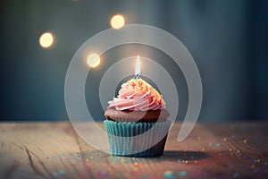 Chocolate cupcake with birthday candle, pink frosting and sugar sprinkles.