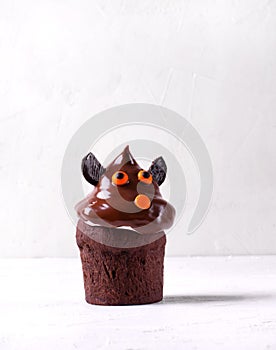 Chocolate cupcake with cute face. Halloween dessert