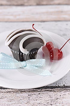 Chocolate cupcake with festive red maraschino cherries - vertical