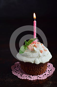 Chocolate cupcake with vanilla cream and candle. Happy Birthday. Dark photo