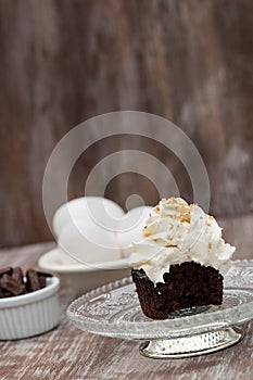 Chocolate Cupcake With Vanilla Frosting On Glass Plate With Eggs