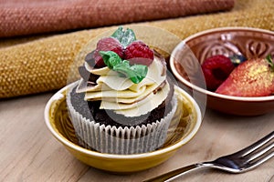 Chocolate cupcake with vanilla frosting and raspberries still life stock images