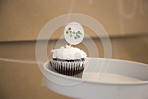 Chocolate cupcake with white frosting on a cake stand