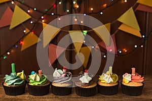 Chocolate cupcakes with candles against festive background