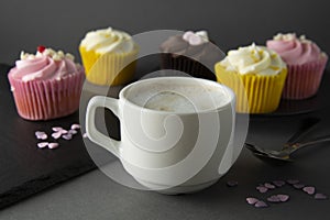 Chocolate cupcakes and coffee , breakfast with colorful cupcakes. Gray background. Sweet dessert