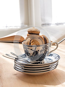 Chocolate cupcakes in teacup, book on background.