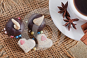 Chocolate and dairy sesame sweets in the form of heart, a cup of fragrant coffee with spices