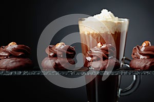 Chocolate dessert with hazelnut and coffee with cream on a black background