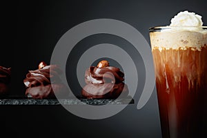 Chocolate dessert with hazelnut and coffee with cream on a black background