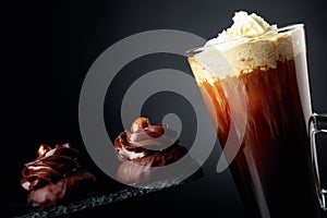 Chocolate dessert with hazelnut and coffee with whipped cream on a black background