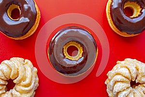 Chocolate Dip Donuts with Honey Cruller Donuts on a red background