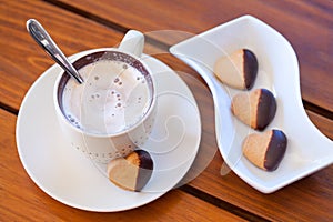 Chocolate dipped heart shaped shortbread cookies and a cup of ca