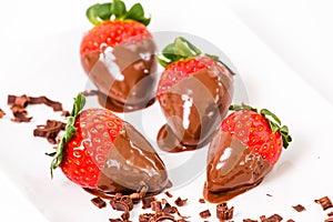 Chocolate dipped strawberries, chocolate pieces around him.