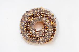 Chocolate donut with frosted glazed and nuts sprinkles top view isolated on white background. Dessert and sweet food concept. Top