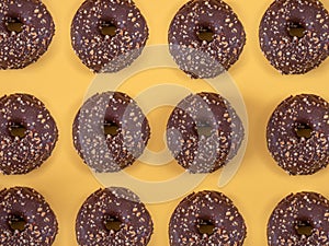 Chocolate donuts with almond pattern on yellow