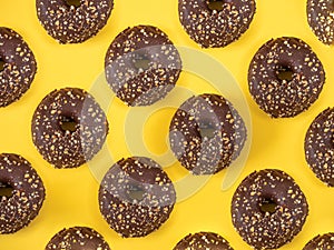 Chocolate donuts with almond pattern on yellow