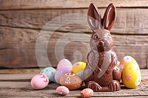 Chocolate Easter bunny and Easter Painted Eggs on wooden background