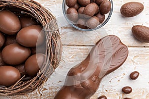 Chocolate Easter bunny, eggs and sweets on rustic background