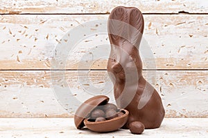 Chocolate Easter bunny, eggs and sweets on rustic background