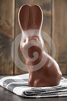 Chocolate Easter bunny, eggs and sweets on rustic background