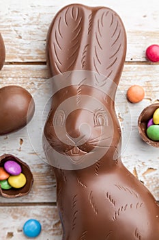 Chocolate Easter bunny, eggs and sweets on rustic background