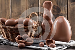 Chocolate Easter bunny, eggs and sweets on rustic background