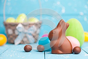Chocolate Easter bunny, eggs and sweets on rustic background
