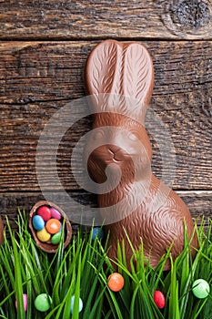 Chocolate Easter bunny and eggs on wooden background