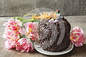 Chocolate Easter cake decorated with a decorative bird and a nest with eggs.