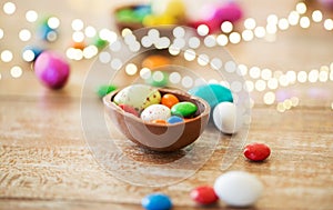 Chocolate easter egg and candy drops on table