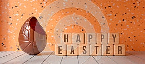 Chocolate easter egg with cubes and the message HAPPY EASTER - 3D rendered illustration