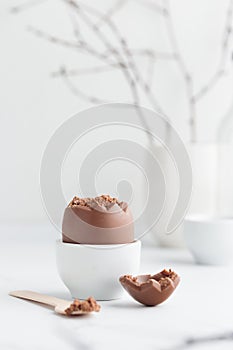 Chocolate easter egg in a white eggholder