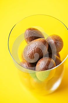 Chocolate Easter eggs in a glass. Easter background concept