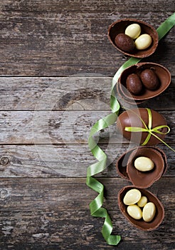 Chocolate Easter eggs on rustic wooden background, top view