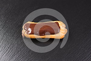 Chocolate eclair on black background. Eclairs with glaze.