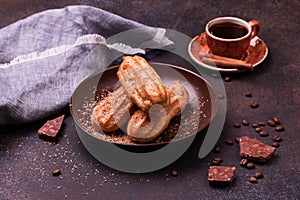 Chocolate eclair and coffee cup on dark background