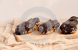 Chocolate eclair on wooden desk food photography. Bekery, cake , choco, pie, confectionary, cream. Three fresh eclairs with chocol