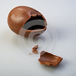 Chocolate egg candy broken on gray background photo