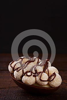 Chocolate egg ith filling for Easter on wooden background