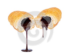 Chocolate filling flows from a croissant on white background