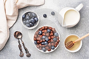 Chocolate flakes made from natural cereals with fresh blueberries, honey and milk. The concept of a healthy wholesome Breakfast.