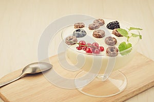 Chocolate flakes with yogurt and berries in glass bowl/chocolate flakes with yogurt and berries in glass bowl on a wooden tray.