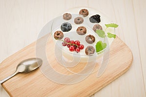 Chocolate flakes with yogurt and berries in glass bowl/chocolate flakes with yogurt and berries in glass bowl on a wooden tray.Top