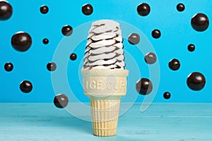 A chocolate flavor ice cream cone with floating chocolate candies horizontal composition