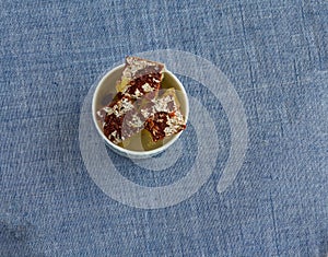 Chocolate flavored petha with silver foil topping,served in bowl on a light background. Top view,backlit.