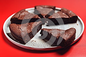 Chocolate Flourless Cake on red background. Soft chocolate gÃ¢teau or Brownie cake