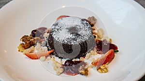 Chocolate fondant lava cake with strawberries serve on white plate