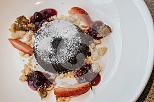 Chocolate fondant lava cake with strawberries serve on white plate